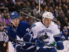 Maple Leafs’ Auston Matthews (left) collides with Vancouver Canucks’ Derek Dorsett on Saturday night at the Air Canada Centre. (CRAIG ROBERTSON/TORONTO SUN)