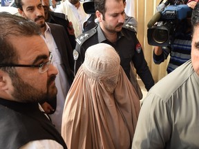 Afghan refugee woman, Sharbat Gula (C), known internationally as the 'Afghan Girl' who appeared on the cover of a 1985 edition of National Geographic magazine, leaves the court in Peshawar on November 4, 2016. An Afghan woman immortalized on a National Geographic cover will be sent back to the war-torn homeland she first fled decades ago, after a Pakistani court ordered that she be deported. A Pakistani provincial minister says his administration should intervene to prevent Gula from being deported. (MAJEEDA MAJEED/AFP/Getty Images)