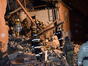 In this Sunday, Nov. 6, 2016, photo, made available by the Russian Ministry for Emergency Situations, emergency rescue teams dig through rubble after an explosion at brick building in Ivanovo, 250 kilometers (150 miles) northeast of Moscow, Russia. Russian emergency officials say the explosion was caused by a gas leak in the apartment building shortly before dawn. (Russian Ministry for Emergency Situations photo via AP)