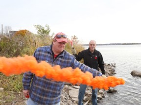 Christian Roy and Dale Holland (front) showcase the different types of flares boaters should have on there vessel to draw attention in case of an emergency.