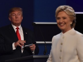 Democratic presidential nominee Hillary Clinton departs the stage following the third and final US presidential debate with Republican nominee Donald Trump (background) at the Thomas & Mack Center on the campus of the University of Las Vegas in Las Vegas, Nevada on October 19, 2016. / AFP PHOTO / Paul J. Richards