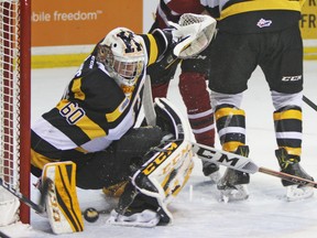 Kingston Frontenacs goalie Jeremy Helvig has a close call as a shot from the Guelph Storm’s Givani Smith bounces behind his foot during an Ontario Hockey League game at the Rogers K-Rock Centre on Sunday. (Steph Crosier/The Whig-Standard)