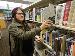 Kristen Bohlmann looks for a book in the stacks at the London Central Library. The public library costs taxpayers $1.77 per use, slightly less than the median cost of $1.90 per use in a comparison of 15 Canadian cities.  (MORRIS LAMONT, The London Free Press)