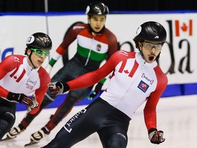 Canada's Charle Cournoyer (left) celebrates his gold medal finish with teammate and silver medallist Samuel Girard (right) as bronze medallist Shaoang Liu of Hungary looks on following the men's 1,000-metre final at the ISU World Cup short track speedskating competition in Calgary on Sunday, Nov. 6, 2016. (Jeff McIntosh/The Canadian Press)