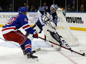 Winnipeg Jets goalie Michael Hutchinson (34) knocks the puck away from New York Rangers right wing Michael Grabner (40) in the second period of an NHL hockey game, Sunday, Nov. 6, 2016, in New York. (AP Photo/Adam Hunger)