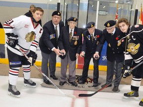 The Mitchell Hawks of the Provincial Junior Hockey League (PJHL) and the Mitchell Legion, br. 128, co-operated on a brief Remembrance Day ceremony last Saturday night, Nov. 5 at the Mitchell & District Arena. Dropping the ceremonial face off for Hawks’ captain Tyler Pauli (left) and Goderich Flyers captain Tyler McCracken (25) were Legion Branch President Ken Eckenswiller, and veterans Norman Dow, Jim Wright and John Ward. ANDY BADER MITCHELL ADVOCATE