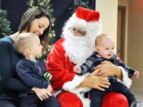 Seven-month-old Wesley Fischer has nothing but smiles for the camera while Santa is deep in conversation with his big brother Dennis, 2, and mom Mary during the well-attended vendor show at the Mitchell & DIstrict Community Centre last Saturday, Nov. 5. Photographer Shelby Graul was one of the vendors on hand. The West Perth firefighters breakfast and United Church bake sale was also a part of the event. ANDY BADER MITCHELL ADVOCATE