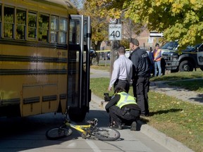 Halton Regional Police investigate a collision involving a school bus and a cyclist. The 10-year-old girl was transported to McMaster Hospital in serious condition. (Andrew Collins photo)