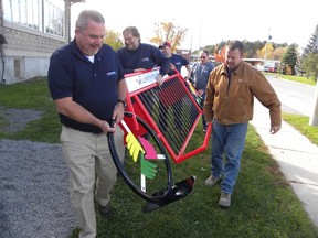 Ernst Kuglin/The Intelligencer
Harold Neumann, Mike MacDonald, Mark Puddy, Bob Kidd and Alwood Dillabough of Kilmarnock Enterprises’ Trenton shop carry a custom-made bike rack donated to the Quinte West Youth Centre by the company last Friday.