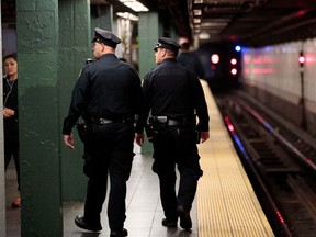 NEW YORK, NY - NOVEMBER 7: Members of the New York City Police patrol a subway station in Times Square, November 7, 2016 in New York City. With both presidential candidates holding their election night events in New York City, the NYPD has stepped up security ahead of election day. (Photo by Drew Angerer/Getty Images)