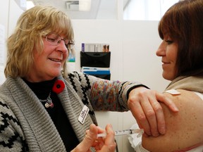 Luke Hendry/The Intelligencer
Registered nurse Lois Farnell-Woodman injects Quinte Health Care medical/critical care program director Christine Wilkinson with influenza vaccine at Belleville General Hospital Monday. Staff vaccinations have increased compared to those of last fall.