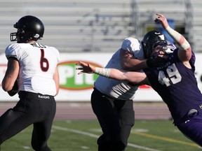 Carleton Ravens offensive lineman Tyler Young keeps Western Mustangs defensive lineman John Biewald, right, away from Ravens quarterback Jesse Mills, left, during their OUA semifinal playoff football game at TD Stadium in London, Ont. on Saturday November 5, 2016. (CRAIG GLOVER, The London Free Press)