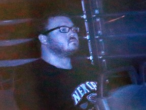In this Monday, Nov. 10. 2014, file photo taken through tinted glass, Rurik Jutting, a British banker, is escorted in a prison bus to a court in Hong Kong. Rurik was convicted of murder Tuesday for killing two Indonesian women in Hong Kong, torturing one of them over three days while using cocaine in a gruesome case that shocked the Chinese financial hub. (AP Photo/Vincent Yu, File)