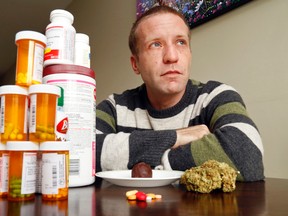 Nate Craig, 35, sits at his family's dining room table in Belleville with some of the medications, forms of medical marijuana, digestive aids and other products he uses to control chronic pain and the drugs' side effects. The victim of a 1999 car accident has prescriptions for painkillers and marijuana but said staff of Kingston General Hospital prevented him from using cannabis products while he was admitted there following spinal surgery. (Luke Hendry/Postmedia Network)