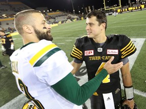 Quarterback Mike Reilly (left) of the Eskimos and Zach Collaros (right) of the Tiger-Cats meet at the end of a CFL game in Hamilton on Oct. 28, 2016. (Peter Power/The Canadian Press)