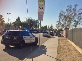 This photo provided by Marco Soto shows a police vehicle outside a middle school in Asuza, Calif., on Tuesday, Nov. 8, 2016, following reports of a shooting near the Los Angeles-area polling site. (Marco Soto/@warzoneintro via AP)