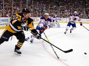 Connor McDavid battles Sidney Crosby for the puck during Tuesday's game in Pittsburgh. (AP Photo)