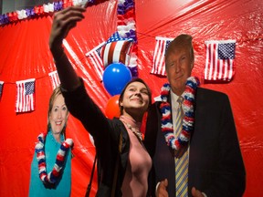 Elizaveta Klimenko take a selfie with a cutout of Donald Trump during a watch event for the 2016 United States presidential election held at Ada Slaight Hall, Daniels Spectrum, in Toronto on Tuesday November 8, 2016. (Ernest Doroszuk/Toronto Sun)