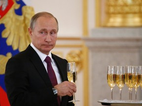 Russian President Vladimir Putin holds a glass during a ceremony of receiving diplomatic credentials from foreign ambassadors in the Kremlin in Moscow, Russia, Wednesday, Nov. 9, 2016. Putin says that Moscow is ready to try to restore good relations with the United States in the wake of the election of Donald Trump. (Sergei Karpukhin/Pool photo via AP)