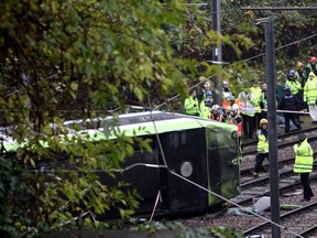 Emergency service workers attend the scene of a derailed tram in Croydon, south London, Wednesday Nov. 9, 2016. A tram derailed in London before dawn on Wednesday, leaving at least 50 people injured and several trapped, the emergency services said. (Steve Parsons/PA via AP)