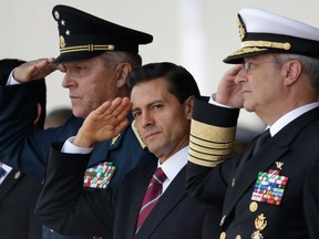 In this Sept. 13, 2016 file photo, Mexico's President Enrique Pena Nieto, center, salutes during a graduation ceremony at the Military Academy in Mexico City. (AP Photo/Rebecca Blackwell, File)