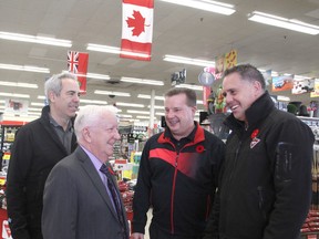 Allan Jones, second from left, the chair of a local group planning to build a wall of remembrance for Canadians who died in wars, meets with Canadian Tire associate dealers Dan Gostlin, left, Rick Smith and Jason Derbyshire at the Bath Road outlet in Kingston on Wednesday as they prepare for a coming military appreciation day at their stores. (Michael Lea/The Whig-Standard)