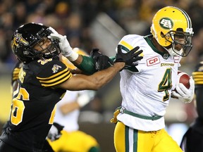 Adarius Bowman fends off a Ticats tackler during a game Oct. 28 in Hamilton. Having spent most of October on the road, the Eskimos say the travel shouldn't have an effect on their performance in the post-season. (The Canadian Press)