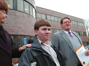 In the March 24, 2005 file photo Patrick Holland, center, stands with his adoptive parents Rita and Ron Lazisky after his adoption was finalized at the Norfolk County Probate Court in Canton, Mass. Holland, 15, was granted a ground-breaking "divorce" from his birth father, Daniel Holland, last summer following his conviction in the murder of Patrick's birth mother.  (AP Photo/Neal Hamberg, File)