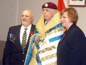 Wallaceburg Legion branch 18 president Len Drouillard, left, and Quilts of Valour's Brenda Oliphant presents a quilt to Wallaceburg veteran Stephen Evans at the Wallaceburg veteran's dinner held on Friday, Nov. 4 at the Wallaceburg Legion. Quilts of Valour provides quilts to injured Canadian veterans to recognize their service and commitment to Canada.