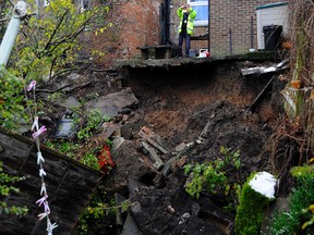 A man stands at the edge of a sinkhole in the garden of a house in Ripon, north England, Thursday Nov. 10, 2016. (John Giles/PA via AP)