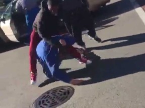 A screengrab from a video which shows two young men beating on an elderly man in Chicago. (Twitter)