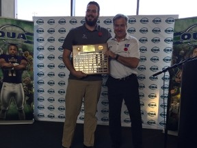 Western offensive lineman Sean Jamieson shows off his hardware with Mustangs head coach Greg Marshall after being named winner of the J.P. Metras Trophy on Thursday in Burlington. (MORRIS DALLA COSTA, The London Free Press)