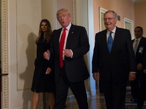 President-elect Donald Trump, accompanied by his wife Melania, and Senate Majority Leader Mitch McConnell of Ky., gestures while walking on Capitol Hill in Washington, Thursday, Nov. 10, 2016, after meeting. (AP Photo/Molly Riley)