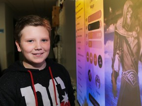 Tim Miller/The Intelligencer
Grade 6 student Casey Kohlsmith stands beside a picture of his Classcraft avatar at St. Michael Catholic School on Thursday in Belleville. Classcraft is a classroom management system where learning is promoted through role-playing and the completing of quests.