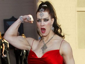 In this Nov. 16, 2003, file photo, Joanie Laurer, former pro wrestler known as Chyna, flexes her bicep as she arrives at the 31st annual American Music Awards, in Los Angeles. (AP Photo/Kevork Djansezian, File)