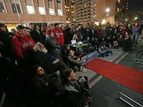 Supporters attend a gala screen of OCAP's film Bursting at the Seams about homelessness on the sidewalk in front of Mayor John Tory's condo on Thursday, November 10, 2016. (Michael Peake/Toronto Sun)