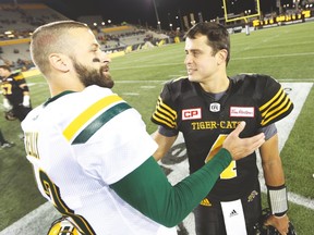 Quarterbacks Mike Reilly (left) of the Eskimos and Tiger-Cats’ Zach Collaros chat following their game two weeks ago. (The Canadian Press)