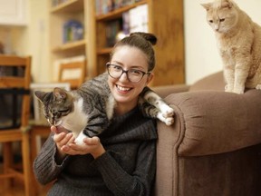 Josée Cyr hangs out with two of her three cats, Tut and Bella, in her home. Cyr is launching Ottawa's first daily cat cafe, set to open this spring. DAVID KAWAI / POSTMEDIA