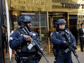 New York City Police officers guard the front of Trump Tower, in New York, Friday, Nov. 11, 2016. The Secret Service and New York City police are going to extremes to protect President-elect Donald Trump when he's at his Manhattan home. Trump's neighbors are now having to navigate swarms of police officers, cement barricades, street closures and checkpoints. (AP Photo/Richard Drew)