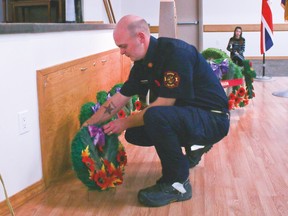 Joel Nygren, a firefighter on the Champion Fire Department lays a wreath during the Remembrance Day Service held at the Champion Community Hall.