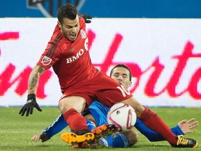 Montreal Impact’s Dilly Duka takes down Toronto FC’s Sebastian Giovinco with a challenge during their game last year. (THE CANADIAN PRESS)
