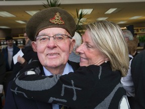 Daughter Jane hugs Jim Jenkins after he received the Legion of Honour from the Consul General of France Marc Trouyet at Remembrance Day ceremonies at Centennial College in Toronto on Friday, November 11, 2016. (Stan Behal/Toronto Sun)