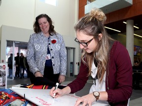 Fourth-year student Laura Wyatt writes her activities on a whiteboard as Queen's University career counsellor Christine Fader looks on during the launch of the third annual It All Adds Up campaign at the Athletics and Recreation Centre in Kingston on Wednesday. (Ian MacAlpine/The Whig-Standard)