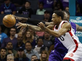 Toronto Raptors guard DeMar DeRozan passes around Charlotte Hornets forward Marvin Williams in the first half of an NBA basketball game in Charlotte, N.C., Friday, Nov. 11, 2016. (AP Photo/Nell Redmond)