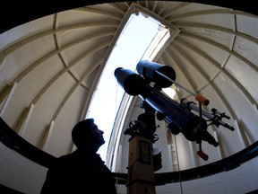 Robert Cockcroft, an assistant professor in physics and astronomy at Western University, stands beneath the telescope housed in the domed roof of the Hume Cronyn Observatory in London. A supermoon will be visible Monday evening. (CRAIG GLOVER, The London Free Press)