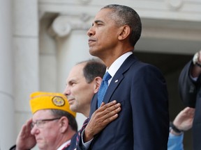 President Barack Obama, with, from left, Robert Swan, left, National Commander of Polish Legion of American Veterans, and Veterans Affairs Secretary Robert McDonald, puts his hand over his chest during a Veteran Day ceremony in the Memorial Amphitheater at Arlington National Cemetery in Arlington, Va., Friday, Nov. 11, 2016. (AP Photo/Pablo Martinez Monsivais)