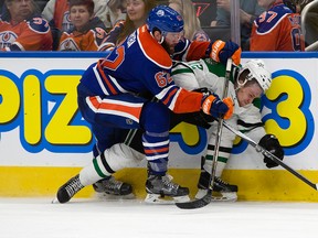 Oilers defenceman Eric Gryba takes Stars forward Radek Faksa out against the boards during Friday's game at Rogers Place. (David Bloom)