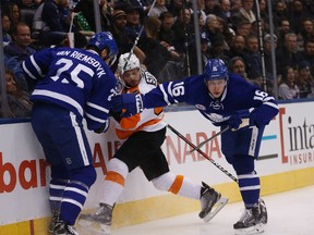 Flyers Mark Streit is pinned by Leafs James van Riemsdyk and Mitch Marner as the Maple Leafs host the Philadelphia Flyers in Toronto on Friday November 11, 2016. Michael Peake/Toronto Sun