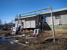 Eight-year-old Shakira Koostachin plays on a swing in the northern Ontario First Nations reserve in Attawapiskat, Ont.