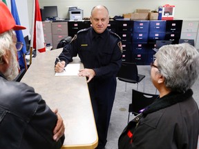 Stirling-Rawdon Police Chief Dario Cecchin makes notes while listening to the policing concerns of Harold residents George and Betty Bailey Saturday.